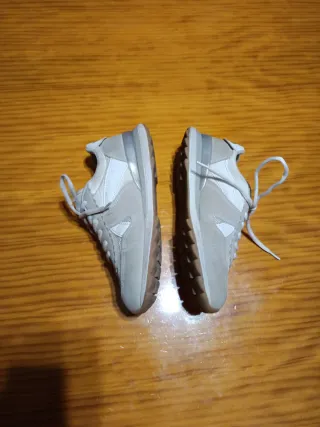 Zapatillas deportivas gris con blanco.