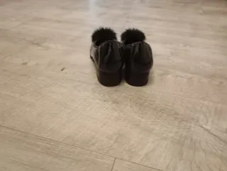 Zapatos negros elegantes con tacón y pompón