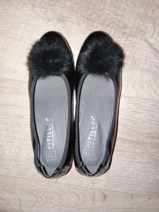 Zapatos negros elegantes con tacón y pompón