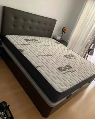 Cama con cabecero tapizado y mesitas