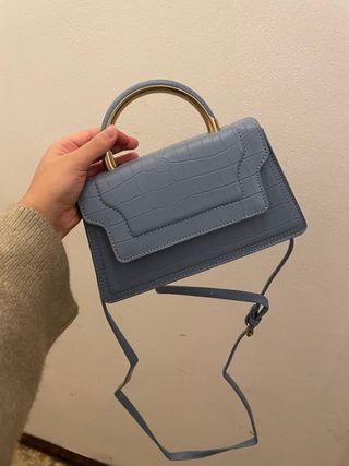 Bolso azul con asa dorada