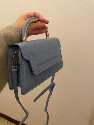 Bolso azul con asa dorada