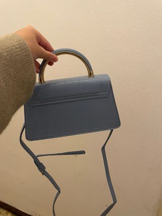 Bolso azul con asa dorada