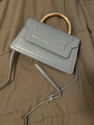 Bolso azul con asa dorada