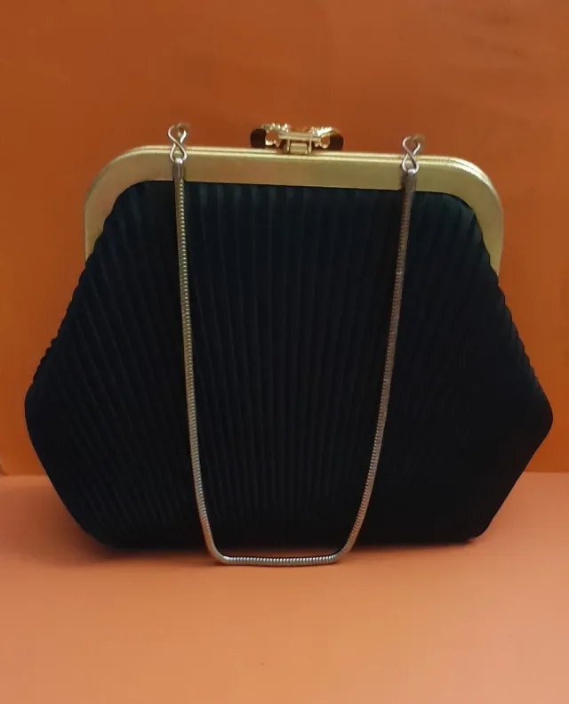 Bolso de mano negro con original cierre dorado.