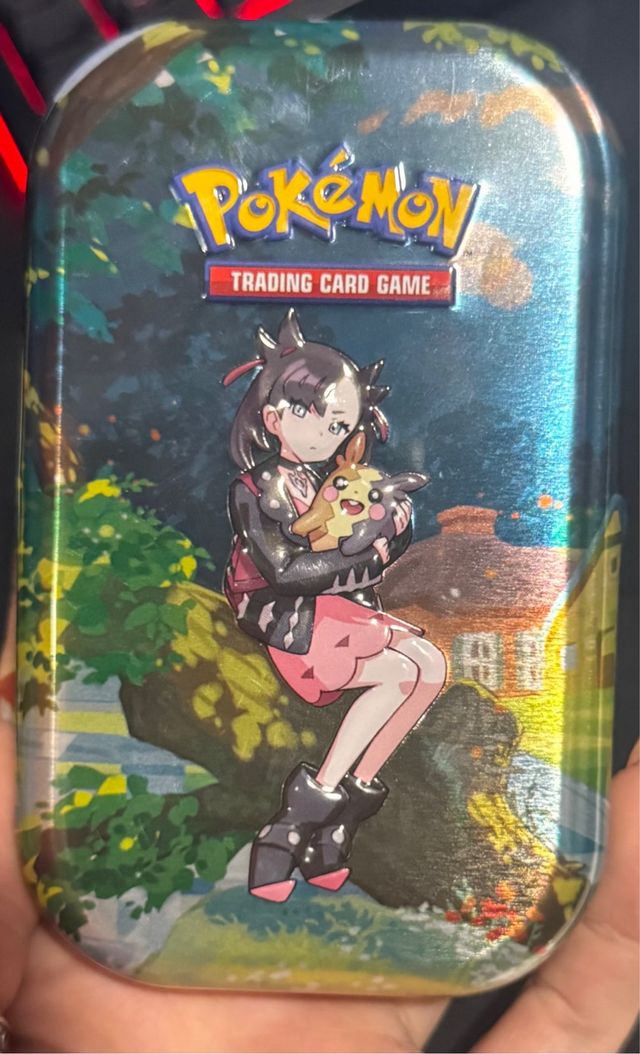 Lata Pokémon Cenit Supremo Marnie con 47 cartas