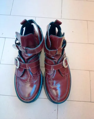 Botines burdeos con hebillas plateadas.