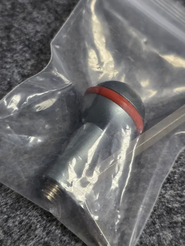 Objeto metálico con banda roja