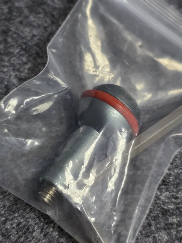 Objeto metálico con banda roja