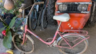 Bicicleta antigua rosa para restaurar