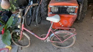 Bicicleta antigua rosa para restaurar