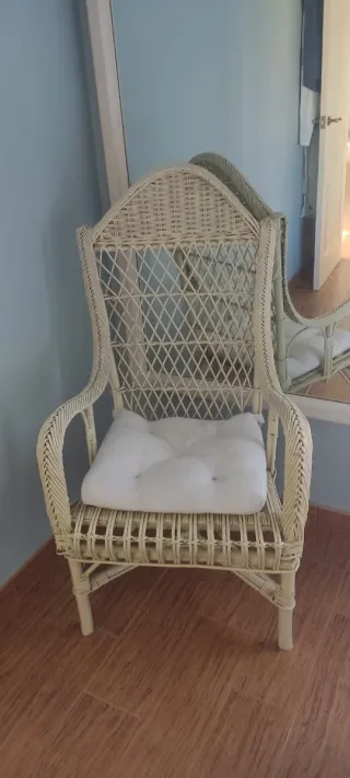 Sillón de mimbre beige con cojín blanco