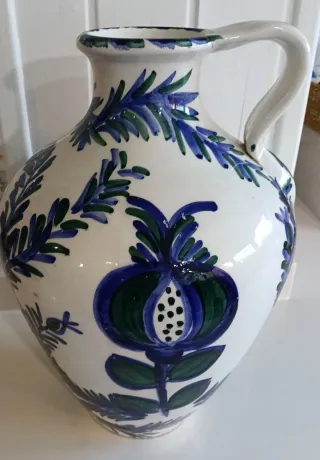 Jarrón blanco con pájaro y hojas