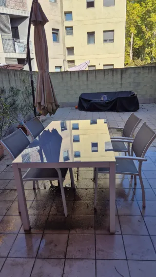 Mesa con sillas de cristal gris para exterior
