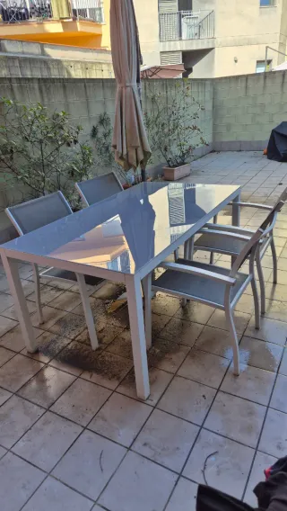 Mesa con sillas de cristal gris para exterior