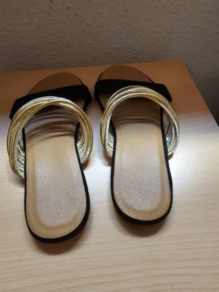 Sandalias planas negras y doradas