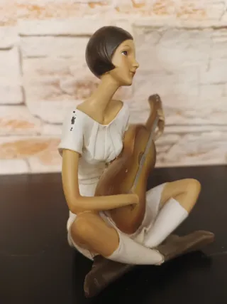 Figura mujer tocando guitarra