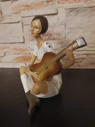 Figura mujer tocando guitarra