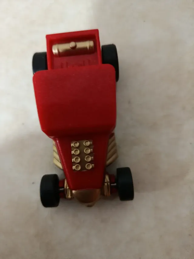 Coche de juguete rojo y dorado