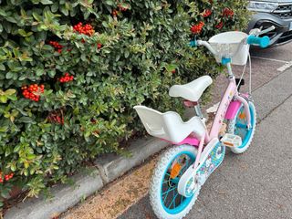 Bicicleta infantil rosa con asiento trasero