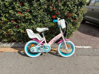 Bicicleta infantil rosa con asiento trasero