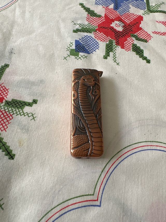 Mechero antiguo con diseño de serpiente