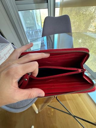 Cartera de piel roja con diseño floral en ante.