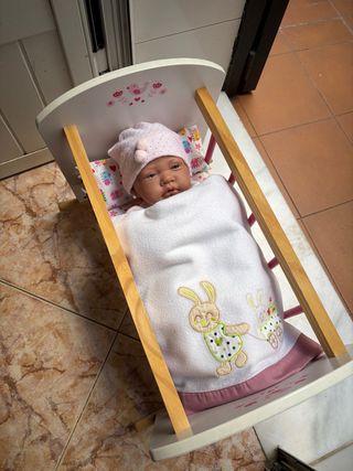 Cuna de juguete con muñeca
