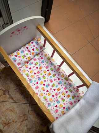 Cuna de juguete con muñeca