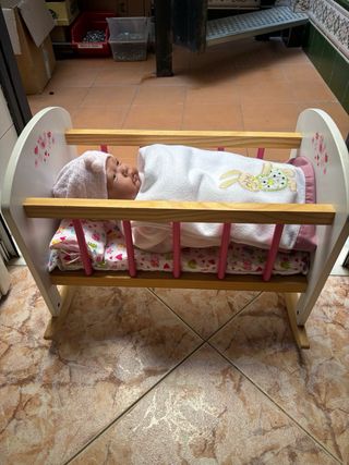 Cuna de juguete con muñeca