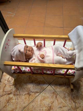 Cuna de juguete con muñeca