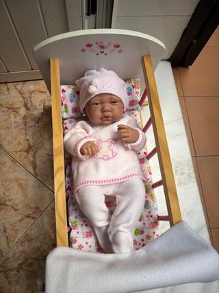 Cuna de juguete con muñeca