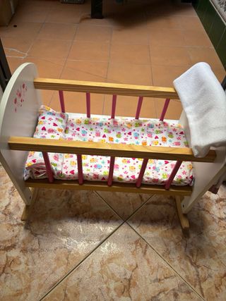 Cuna de juguete con muñeca