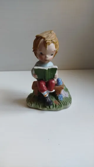 Statuetta vintage bambino legge libro