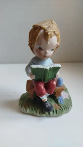 Statuetta vintage bambino legge libro