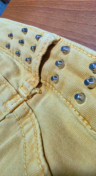Pantaloni strappati con pizzo giallo senape.
