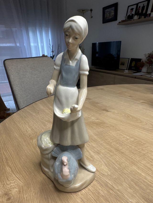 Figura de porcelana de mujer con pavo