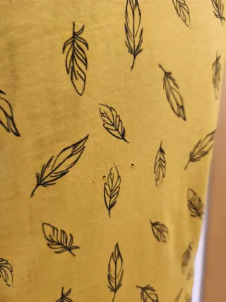 Camiseta mostaza con estampado de plumas