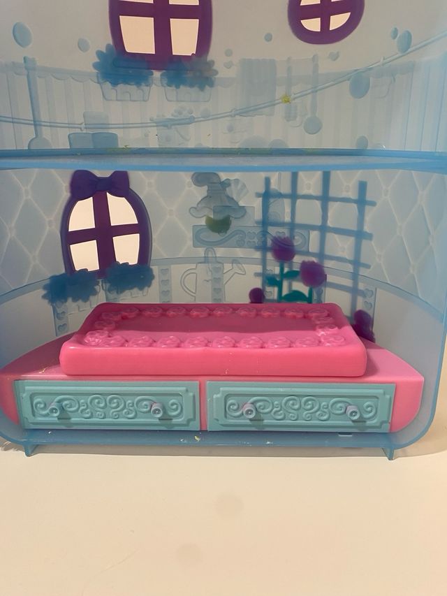 Casa de muñecas azul con lazo rosa