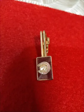Barra de corbata dorada con esmalte rojo