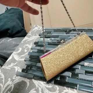 Bolso de fiesta dorado con detalles brillantes
