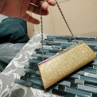 Bolso de fiesta dorado con detalles brillantes
