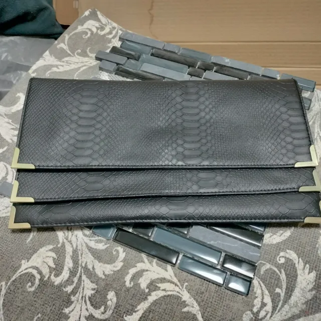 Cartera de mano negra con detalles dorados