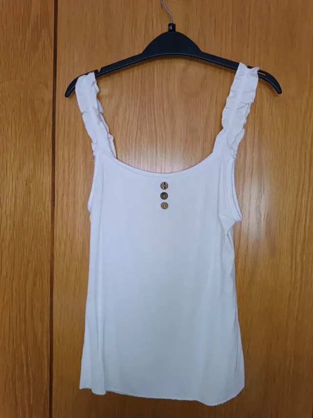 Top blanco sin mangas con volantes