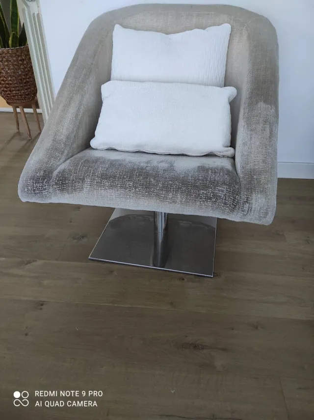 Sillón de diseño de salón beige y base metal.