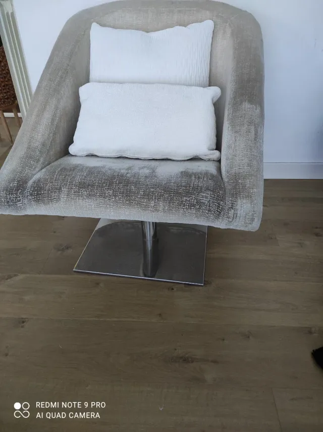 Sillón de diseño de salón beige y base metal.