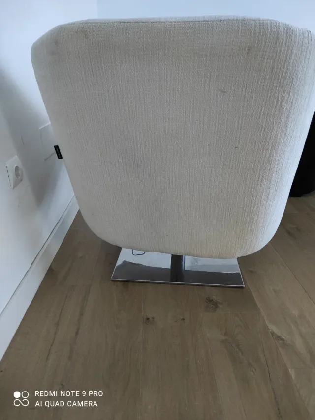 Sillón de diseño de salón beige y base metal.