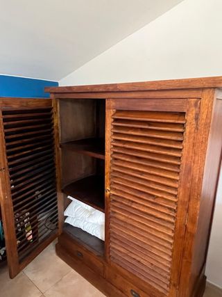Armario de madera con puertas de lamas