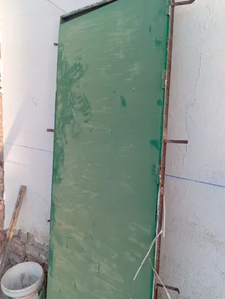 Puerta de hierro verde por el exterior y marron