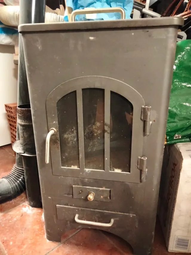 Estufa de leña metálica con puerta de cristal